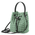 Una borsa a mano da donna modello secchiello della collezione BPrime Bags, in tessuto termoformato 3D Cube, con chiusura con lacci, manico e tracolla rimovibile in pelle.