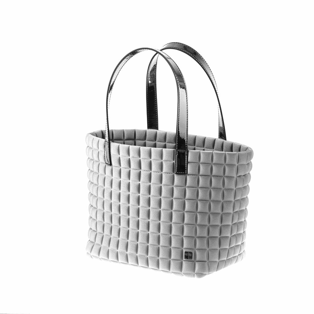 una borsa da donna modello shopping della collezione BPrime Bags, realizzata con il tessuto riciclato termoformato 3D Cube, con chiusura a bottone magnetico, manici e tasca interna in materiali a scelta come pelle, bio veg mais o laminato.