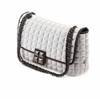 una borsa da donna a tracolla della collezione BPrime Bags, realizzata con il tessuto riciclato termoformato 3D Cube, con chiusura a girello e tracolla a catena regolabile.