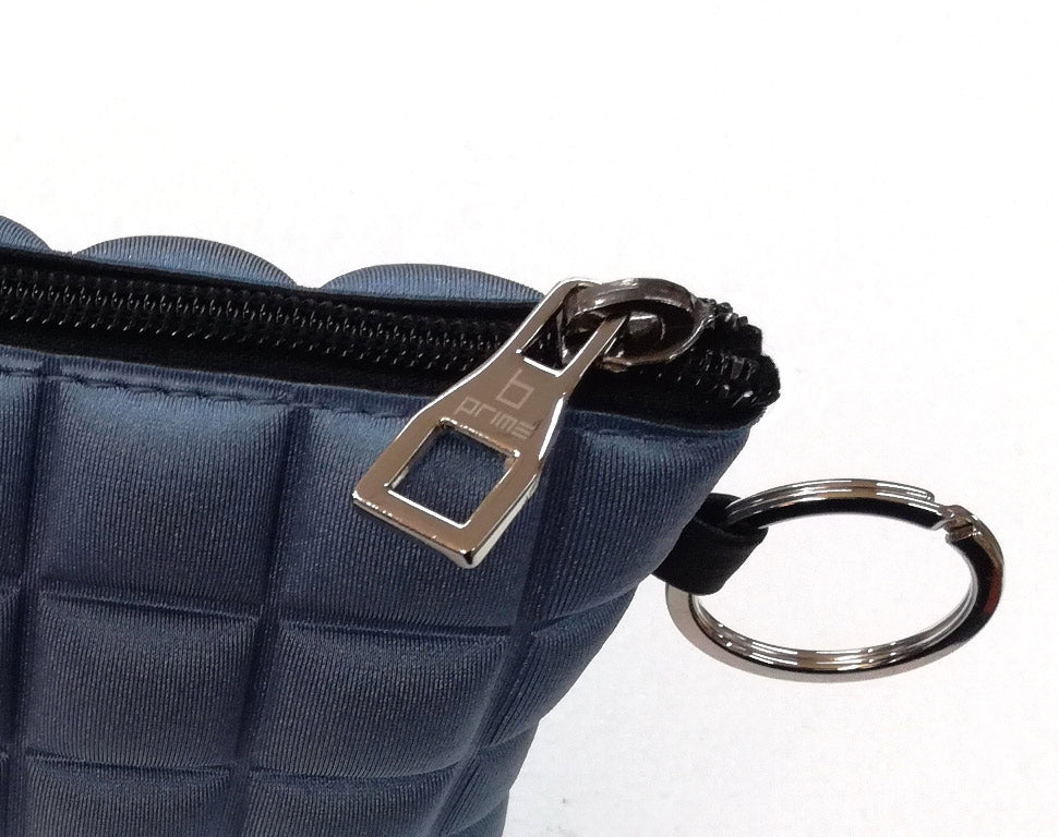 Un dettaglio della mini borsetta da donna della collezione BPrime Bags, realizzata con il tessuto riciclato termoformato 3D Cube e chiusura a zip.